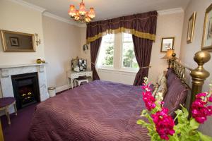 a bedroom with a purple bed and a fireplace at The Villa in Robin Hoods Bay in Robin Hood's Bay