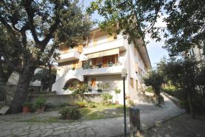 - un bâtiment blanc avec un balcon orné de plantes dans l'établissement Appartamenti Pino Italico, à Castiglioncello