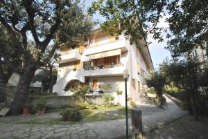 un edificio blanco con un balcón con plantas. en Appartamenti Pino Italico, en Castiglioncello