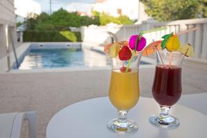 two drinks sitting on a table next to at Villa Apartments Art in Trogir