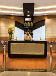 a man standing behind a bar in a hotel lobby at Boudl Al Malaz in Riyadh +43 photos
