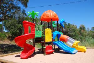 un parque infantil con toboganes coloridos en Residence Ribellinu en Pianottoli-Caldarello