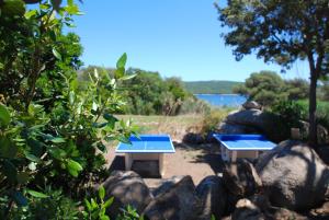 two picnic tables sitting next to some rocks at Residence Ribellinu in Pianottoli-Caldarello