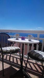 uma mesa branca e cadeiras numa varanda com o oceano em Apartments Zunic em Trogir