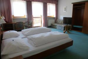 a bedroom with a bed with white pillows on it at Blaue Traube in Gebenbach