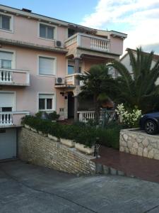 a building with a car parked in front of it at Apartmani MM in Tkon