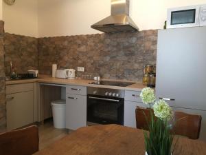 a kitchen with a stove and a table in it at Wohnen auf dem Wallwitzhof in Lutherstadt Wittenberg