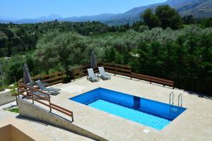 a swimming pool with two chairs and a swimming pool at Villa Ikaros in Kalamitsi Amygdali