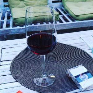 un bicchiere di vino rosso seduto su un tavolo di Hotel La Mimosa a Capalbio
