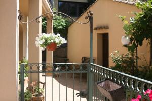 un balcone con fiori in una pentola su una recinzione di Appartamento A Casa di Gesuè a Piazza Armerina