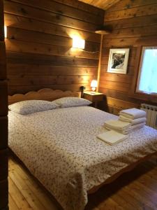 a bedroom with a bed in a log cabin at Chalet des Mélèzes in Pila