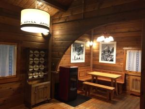 a room in a log cabin with a wooden table and bench at Chalet des Mélèzes in Pila