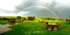 a rainbow over a yard with a table and chairs at The Huntsman Inn in Holmfirth