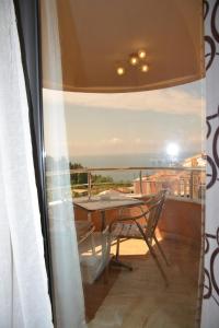 a table and chair on a balcony with a view at Guest House Evropa 2 in Ulcinj