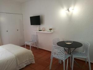 1 dormitorio con 1 cama, mesa y sillas en Appartement Albufeira 402C en Albufeira