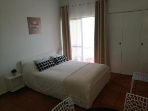 1 dormitorio con cama grande y ventana grande en Appartement Albufeira 402C en Albufeira