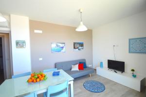 a living room with a table and a blue couch at Yachting Apartment in Marzamemi