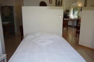 SénasにあるChez MiLyの白い壁のドミトリールームのベッド1台分です。
