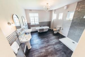 a bathroom with two sinks and a tub and a shower at Birchover Bridgford Hall in Nottingham
