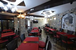 ein Restaurant mit roten Tischen und Stühlen und einer Steinmauer in der Unterkunft Villa & Winery Mal Sveti Kliment in Ohrid