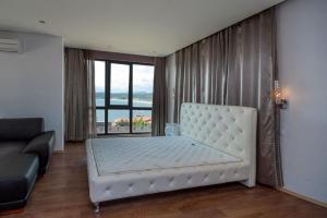 Una cama blanca grande en una habitación con ventana. en Luxury House on Buzhaka, en Sozopol