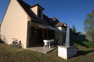 une maison dotée d'une terrasse avec une table et des chaises dans l'établissement Le Port Mesnil, à Mesnil-Saint-Père