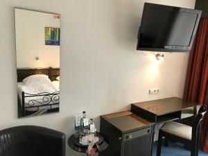 a hotel room with a desk and a tv on the wall at Hotel Rheinlust in Boppard