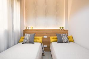 twee bedden naast elkaar in een kamer bij Viento FreshApartments by Bossh Apartments in Málaga