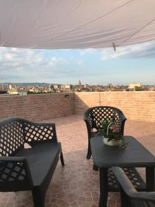 a patio with two chairs and a table with a view at Zagarella House in Catania