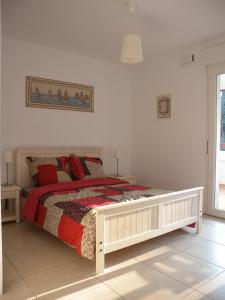 a bedroom with a bed with red pillows at HENDAYE- T2 3*-Wifi-350m plage-terrasse-garage in Hendaye