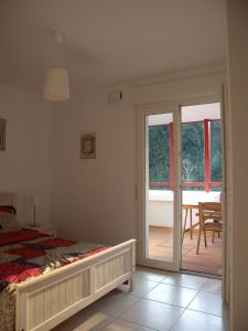 a bedroom with a bed and a sliding glass door at HENDAYE- T2 3*-Wifi-350m plage-terrasse-garage in Hendaye