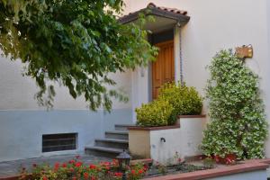 a white house with a door and some flowers at Il piccolo ristoro in Arezzo