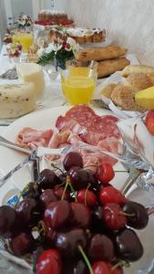 una mesa llena de alimentos con uvas y otros alimentos en Daphnae House, en Palma di Montechiaro