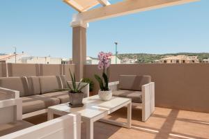 a patio with couches and tables on a roof at Xenia Hotel in Villasimius