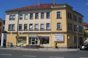 a large yellow building with a sign in front of it at Ferienwohnung am Schunckpark in Dresden