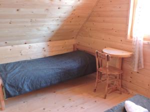 a bedroom with a bed and a desk in a log cabin at Lodge Nagramak in Sekulić 