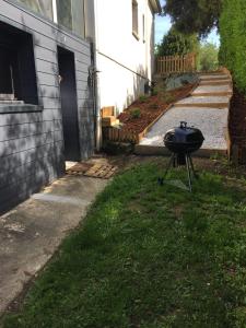 a grill sitting in the grass next to a house at Jard marais océan in Jard-sur-Mer