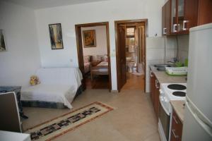 uma cozinha com uma cama e um lavatório num quarto em Apartments Oasis em Tivat