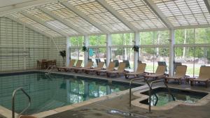 a pool with chairs and tables and a pool of water at Lovely Townhouse with Views in Lincoln