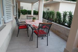 a table and chairs sitting on a balcony with a table and chairs at Apartments Jadranka in Novalja