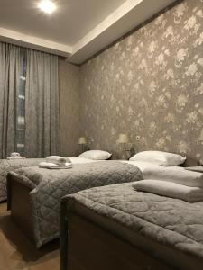 モスクワにあるHotel Compasのベッドルーム1室(ベッド2台付)、花の壁が備わります。