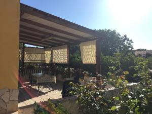patio ze stołem, krzesłami i kwiatami w obiekcie B&B Alvi w mieście Fertilia