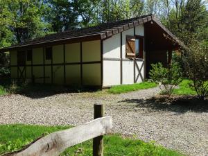 a small green and white cabin with a wooden fence at Chalets du pontot in Le Fay