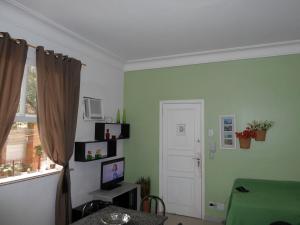 sala de estar con paredes verdes y ventana en Temporada Rio Studio Lily 2 - Perto do Cristo e de Copacabana, en Río de Janeiro