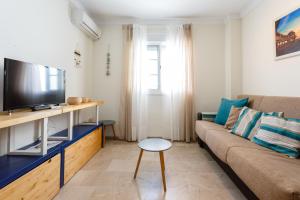 a living room with a couch and a tv at El Atico de las MARINAS free Parking by Cadiz4Rentals in Cádiz