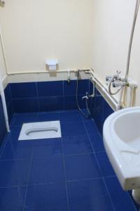 a blue tiled bathroom with a toilet and a sink at Ancient Lahij Guest House in Lahıc