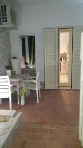 ポルト・チェザーレオにあるCasina Cucciのパティオ(白い椅子、テーブル、ドア付)