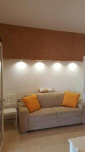 ポルト・チェザーレオにあるCasina Cucciのリビングルーム(オレンジ色の枕が付いたソファ付)