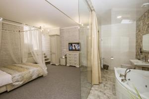 a bathroom with a bed and a tub and a sink at Mini Hotel Ryleev in Kharkiv
