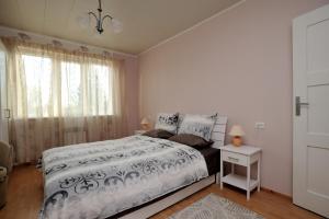 een witte slaapkamer met een bed en een raam bij Jaani Külaliskorter in Pärnu